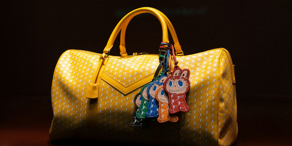Yellow bag with colorful character bag charms, photographed by zai Dan